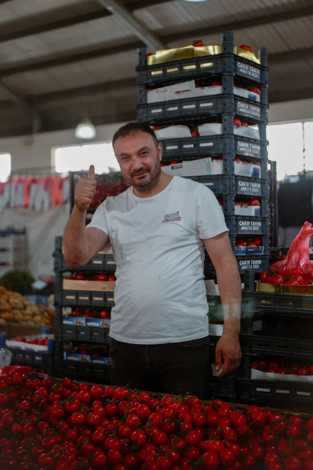 Taze ürünlerin sergilendiği yerel pazar tezgâhı ve satıcı